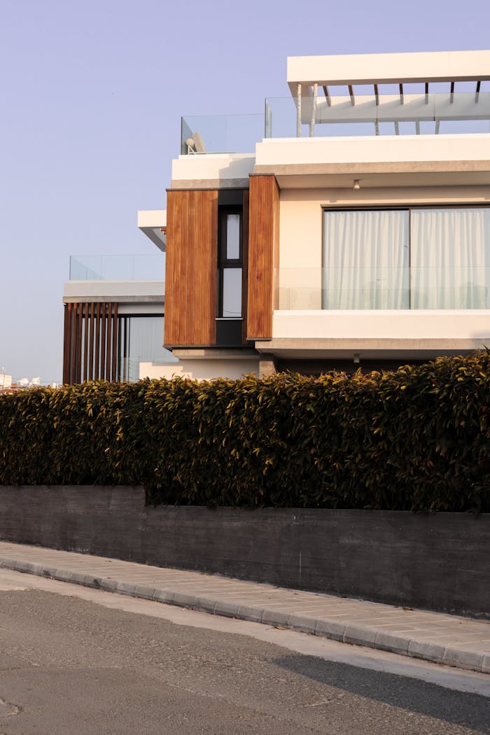Elegant modern villa with wooden accents and lush greenery in urban setting.
