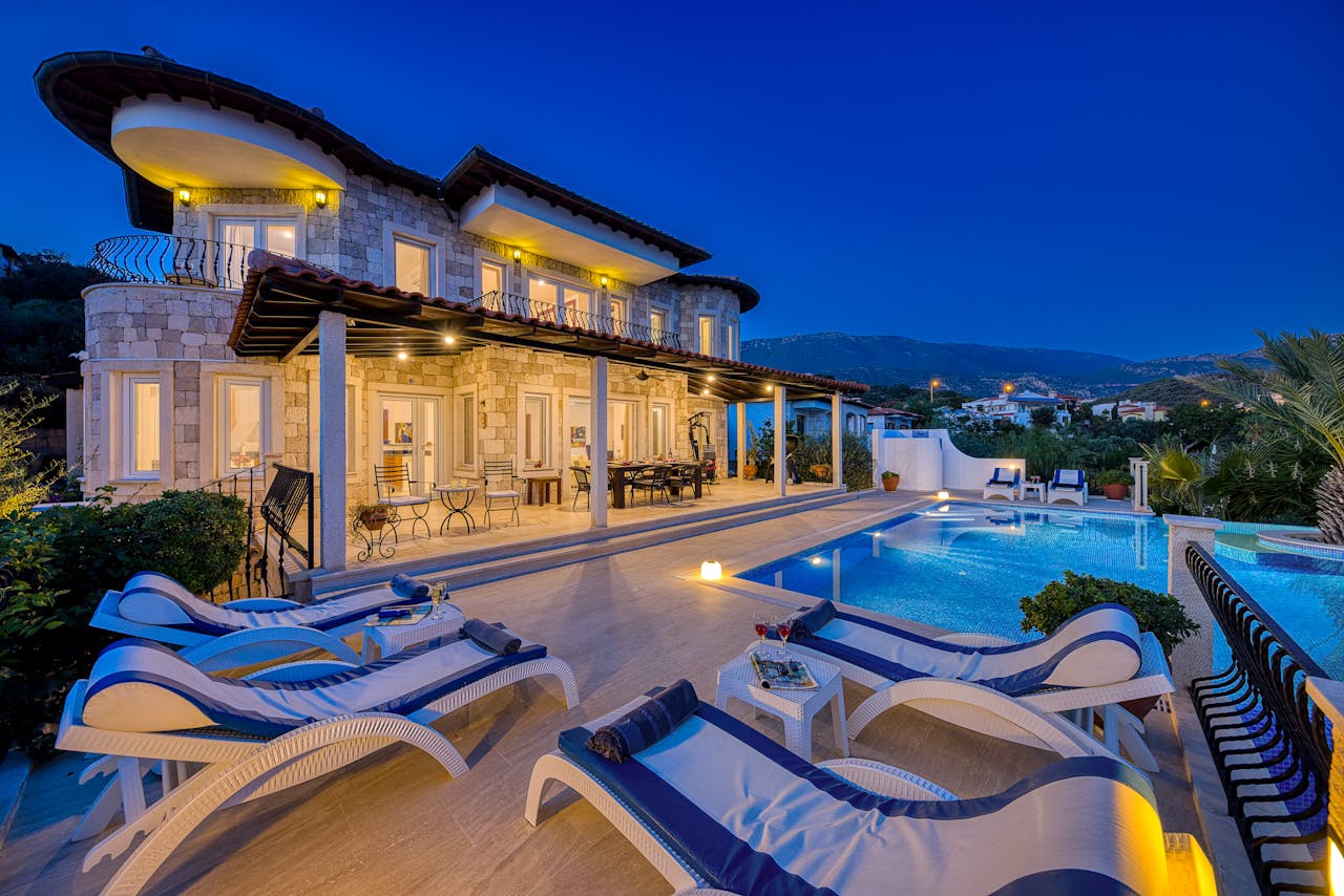 Stunning villa with poolside view during dusk, perfect for a luxurious vacation stay.